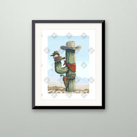 Sparrow Saguaro art print in a black frame on a wall